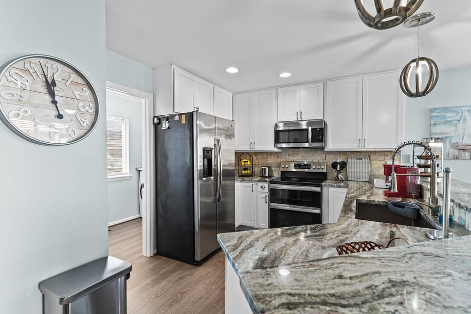 Step into your gourmet kitchen with marble counters, stainless steel appliances, and modern fixtures ready for your culinary adventures.
