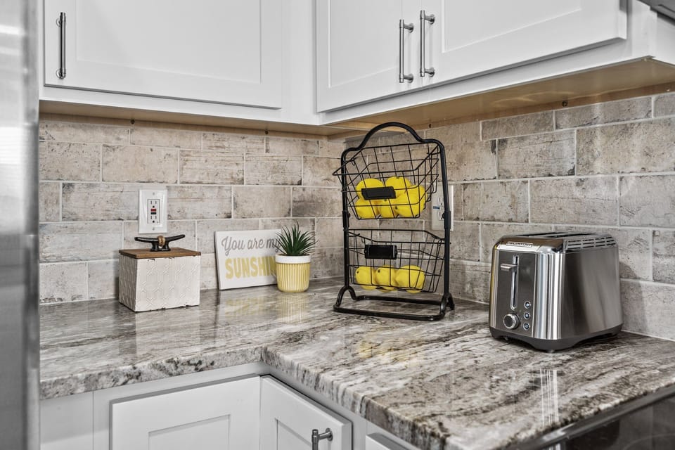 Wake up to your sunny kitchen corner where fresh fruit and morning toast await on beautiful granite counters.