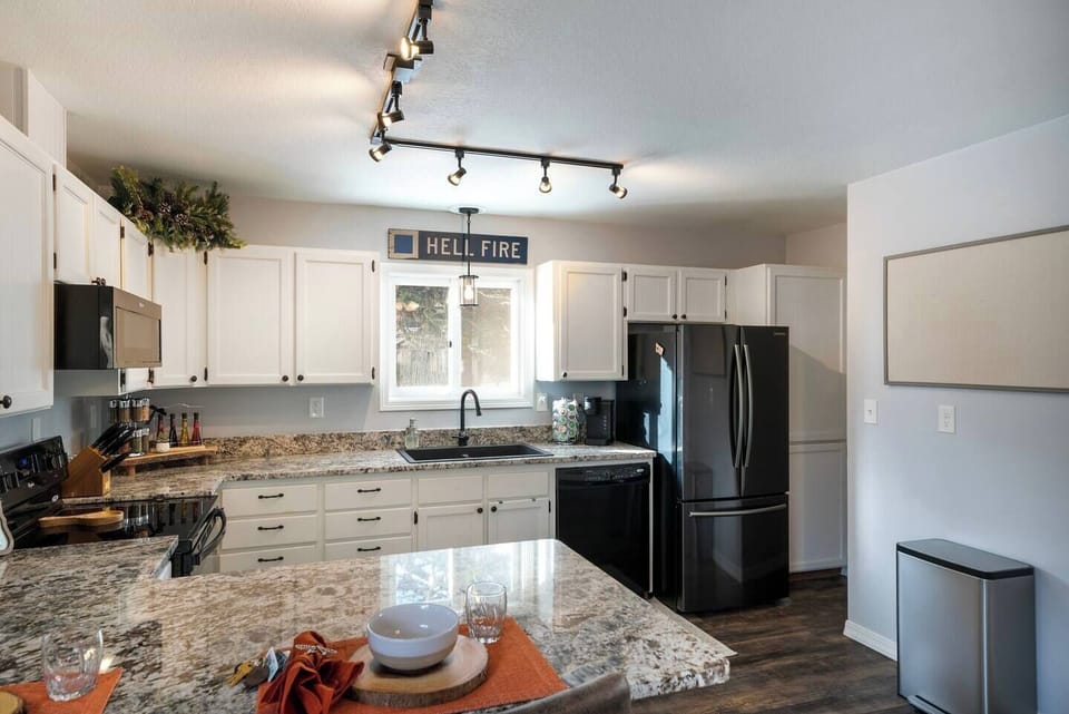 Kitchen fully equipped with cooking utensils, dishes, pots and pans.