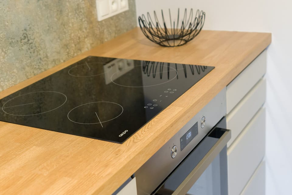 A close-up of a black stovetop with a decorative bowl, emphasizing functionality and style.
