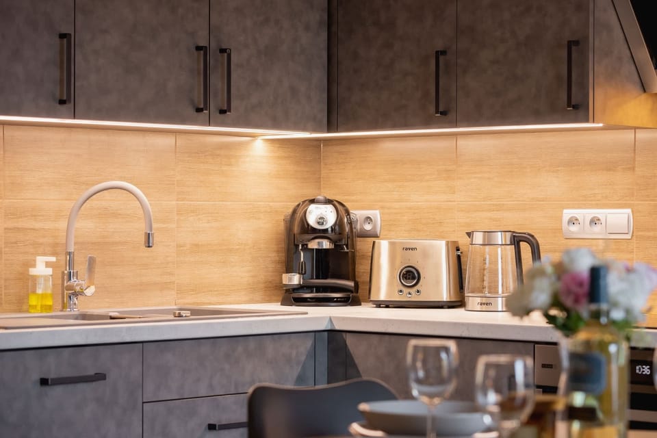 A close-up of the kitchen area with dark cabinets, wooden countertops, and a coffee machine.
