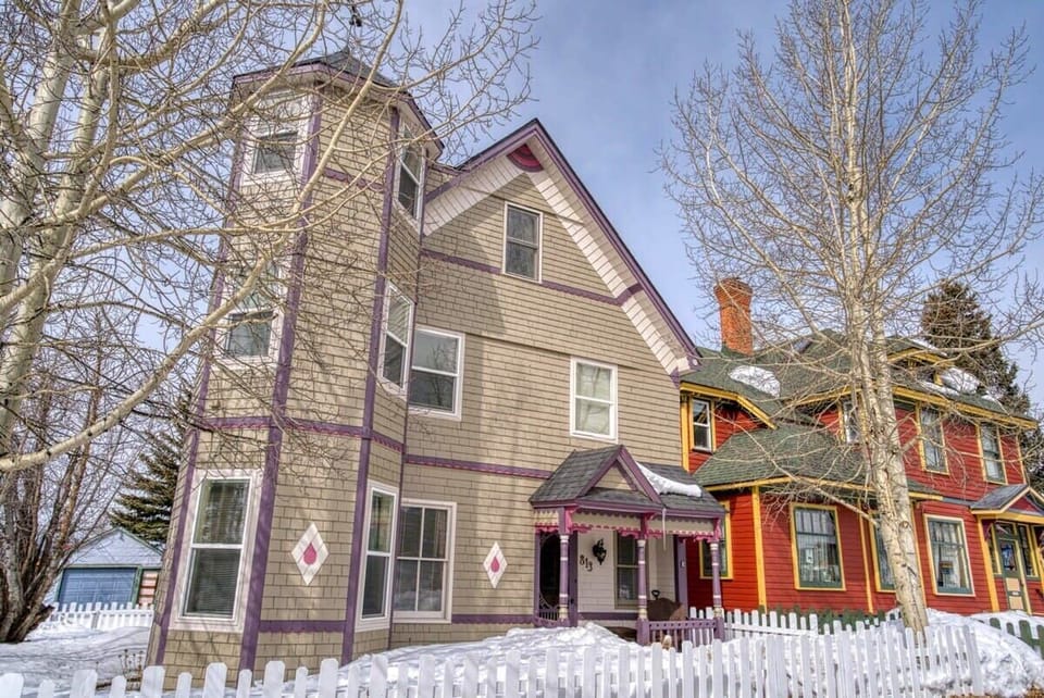 【Exterior】Side angle on the Victorian — three full stories painted in original silver-rush colors.
