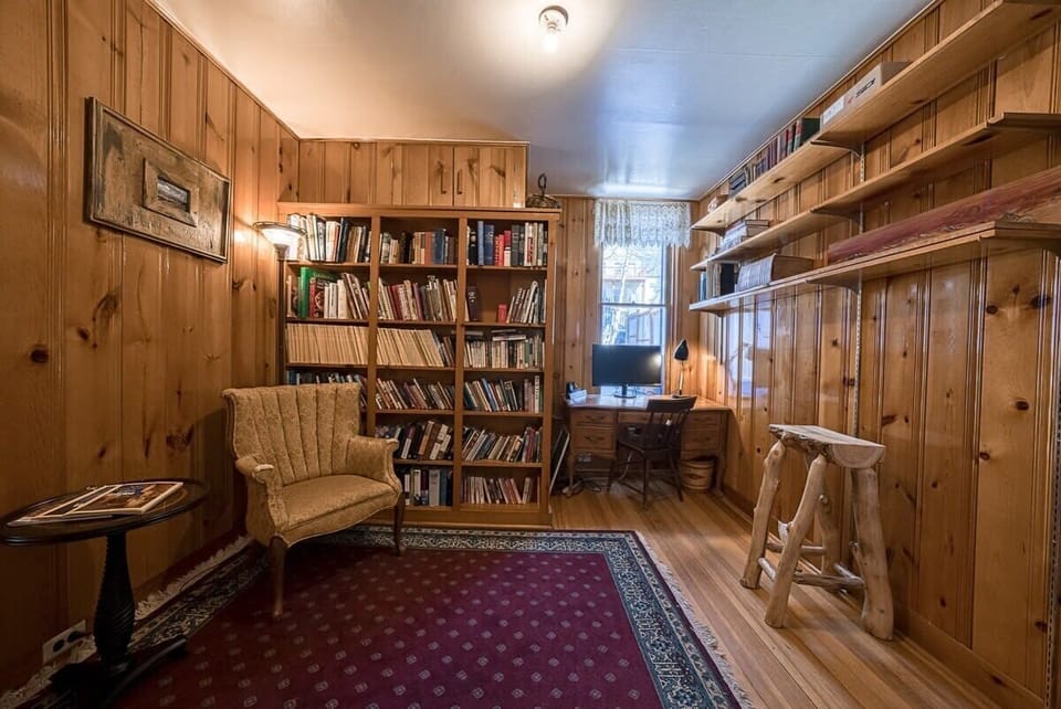 【Library】Wood-paneled reading room with a full wall of books