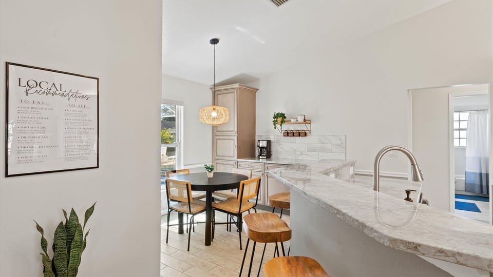 Modern kitchen complete with all amenities, a chic island bar for 3, and a charming dining spot for 4 guests.