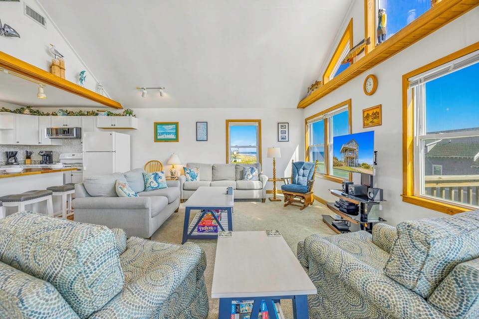 Relax in your bright open living space with vaulted ceilings and coastal views through large windows.