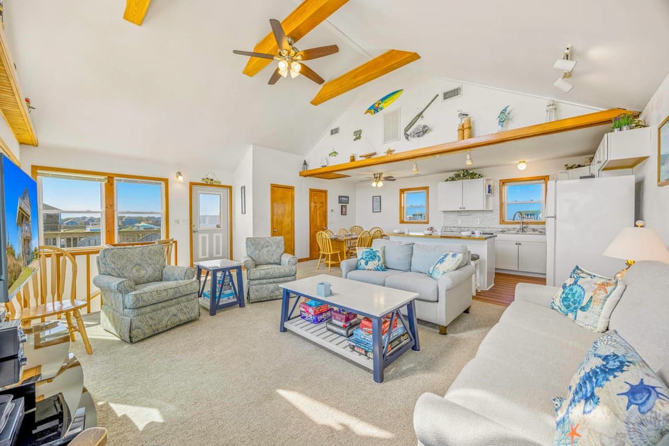 Relax in your bright, open living space where exposed beams frame comfortable seating and a full kitchen awaits your culinary adventures.