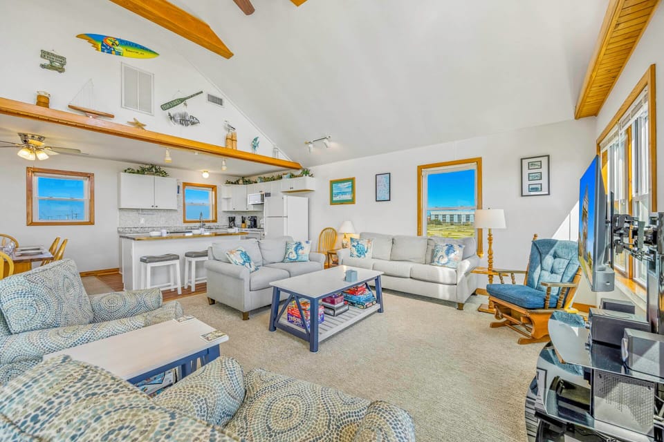 Sink into plush sofas in your spacious living area where coastal blues meet warm wood accents and ocean views frame your perfect getaway.
