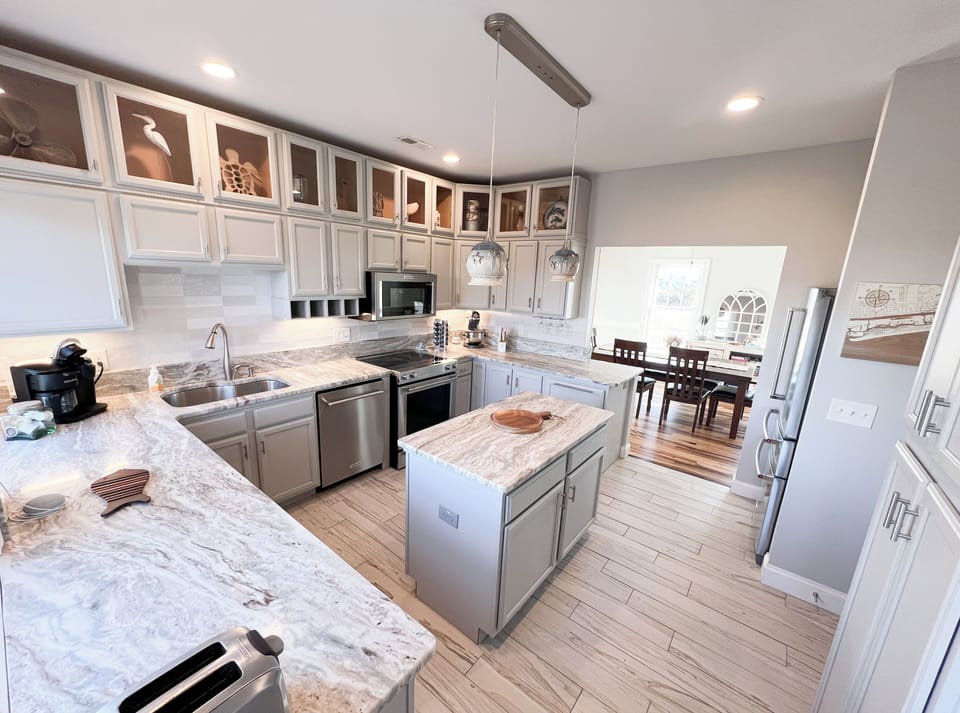 Large kitchen with island, 2 barstools overlooking the intracoastal and adjacent dining room