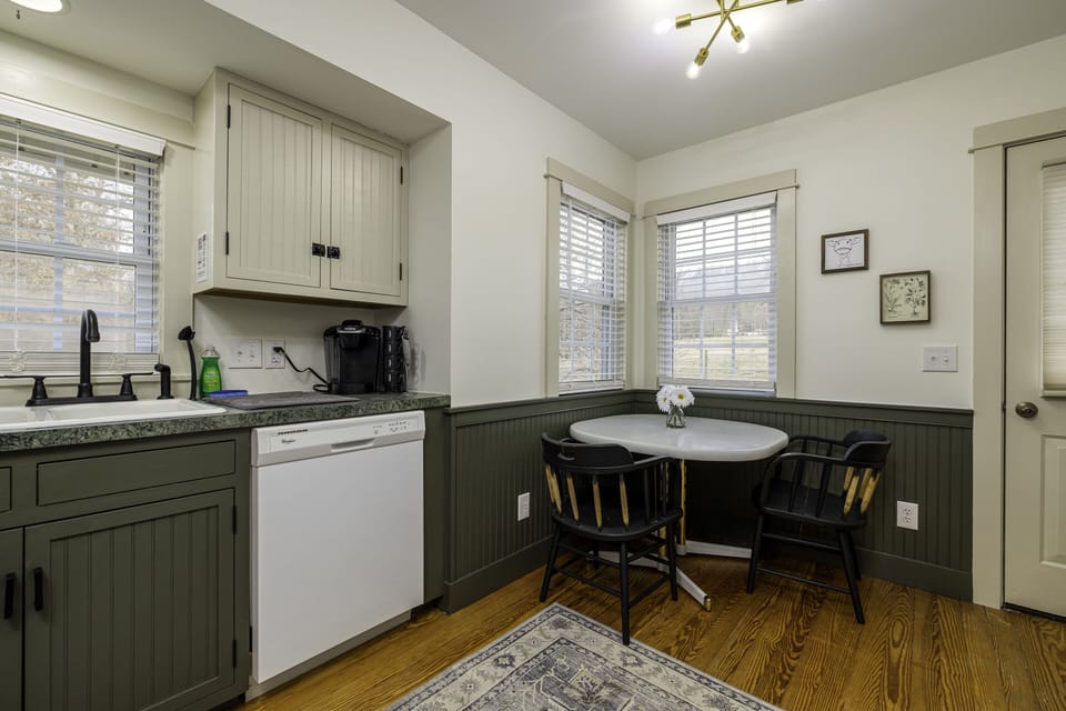 Quaint kitchen with dishes, pots and pans & other utensils.