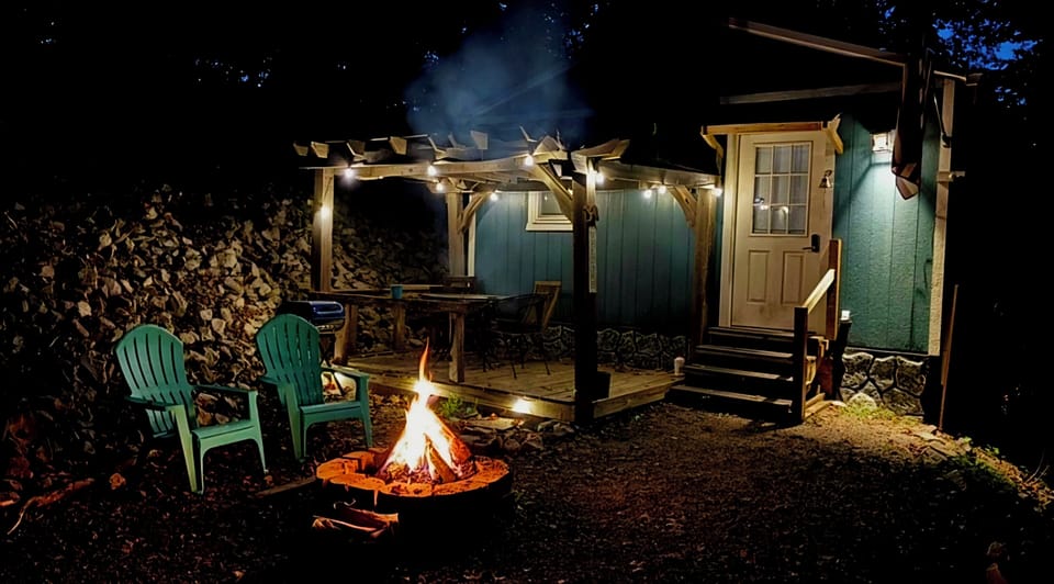 Pergola with table and chairs, fire pit with adirondack chairs. 