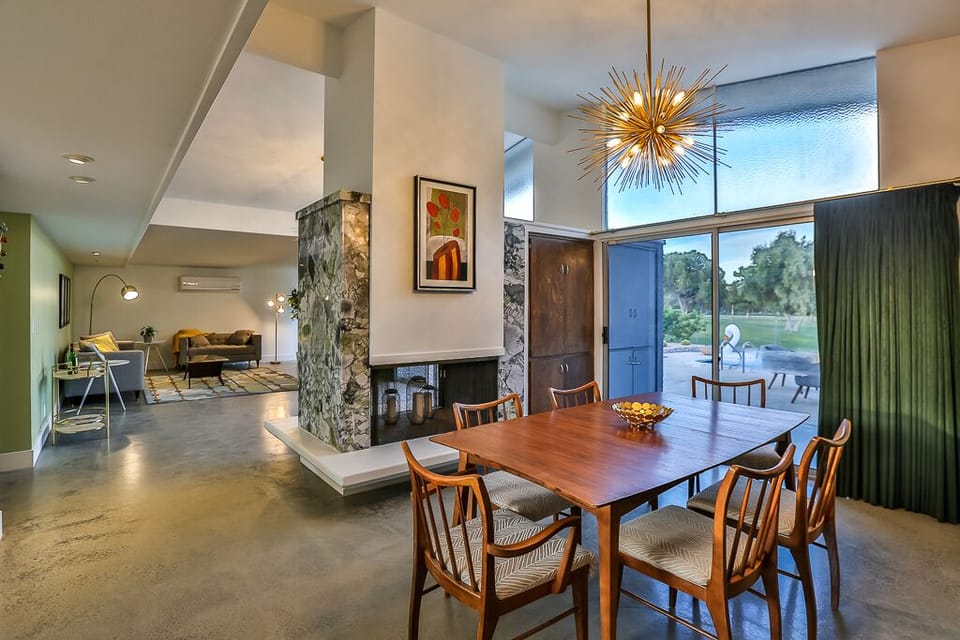 View from dining room into living room, both with golf course views.