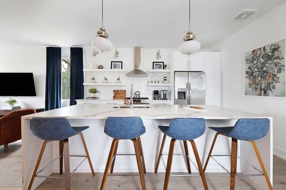Clean and Spacious Kitchen with Sleek Countertops and Additional Seating
