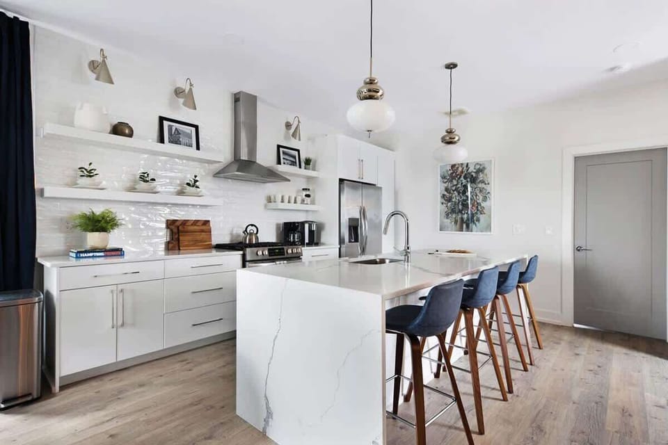 Clean and Spacious Kitchen with Sleek Countertops and Additional Seating
