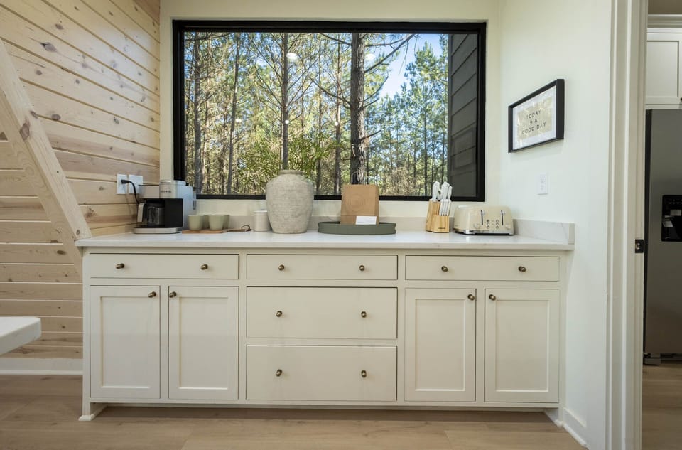 "Where the day's first coffee awaits in a cabin among the pines, readying us for adventure with every sunlit sip."