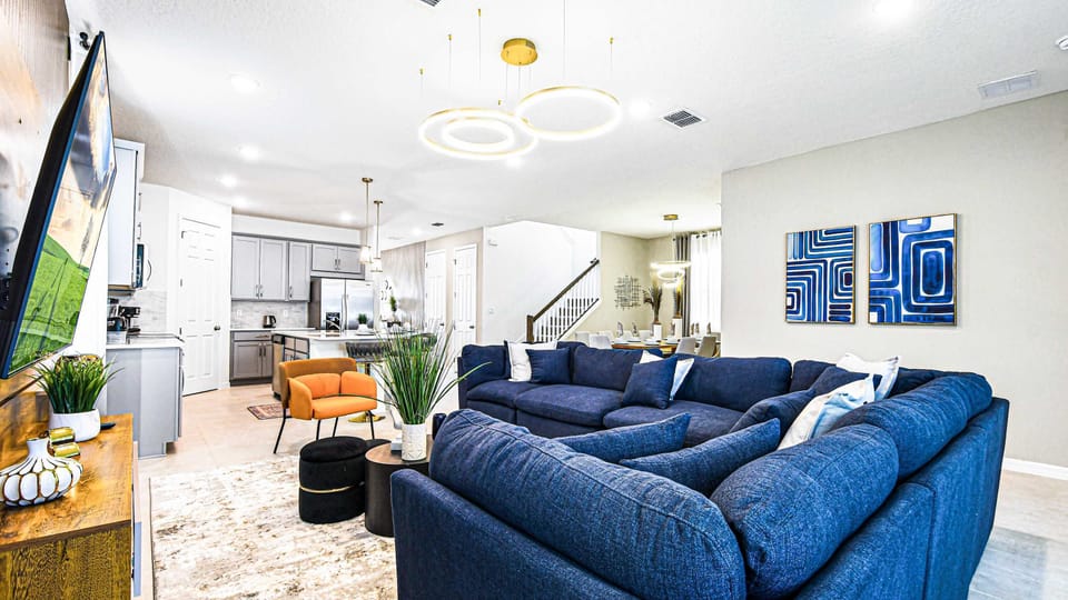 Modern open-concept living area with cozy seating, elegant lighting, and decor.