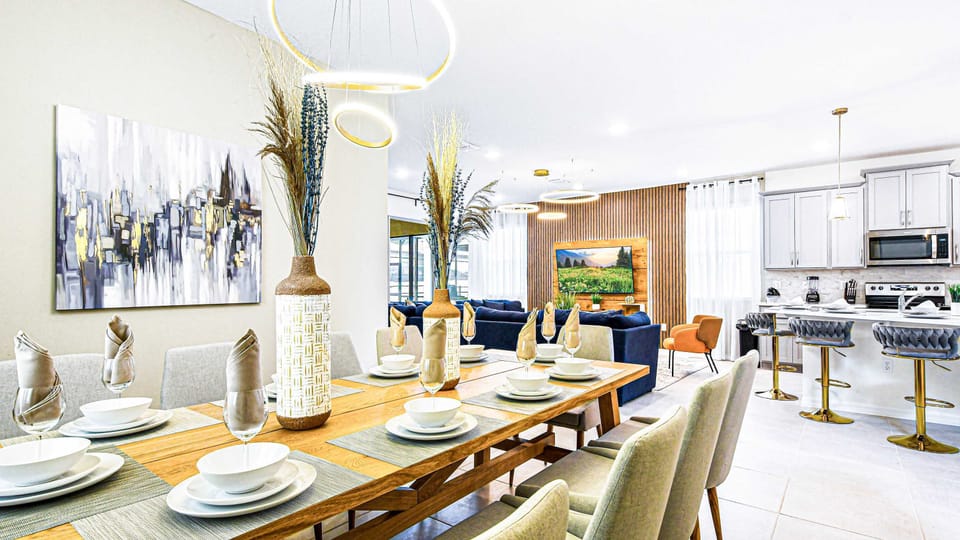 Elegant dining area with modern decor, open kitchen, and natural light.
