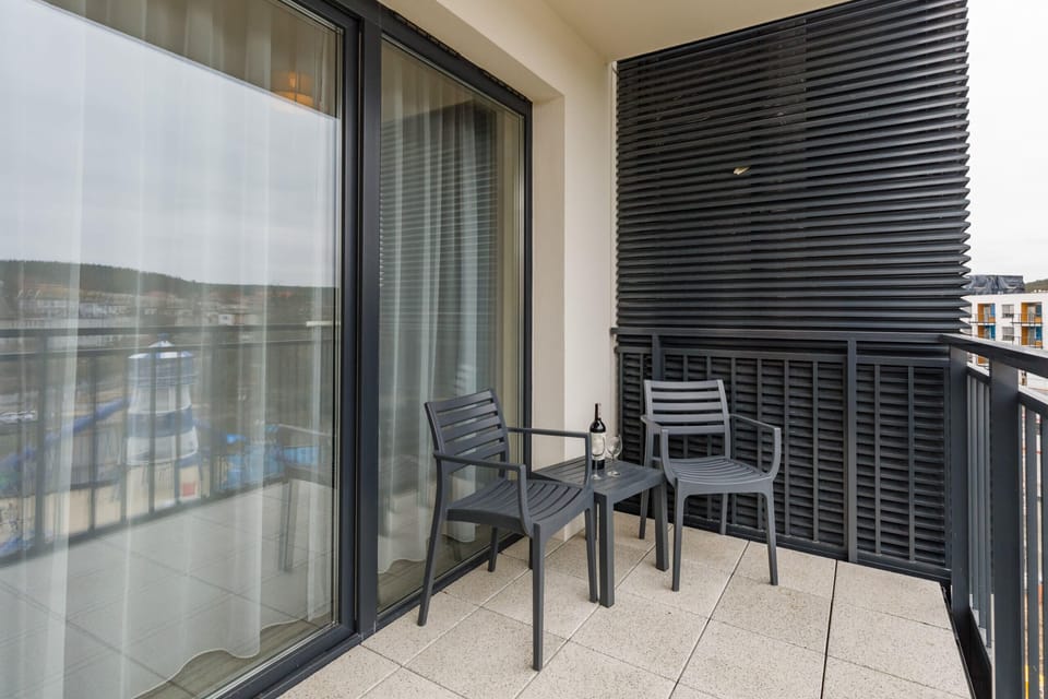 A balcony with outdoor furniture, offering a relaxing view of the city.
