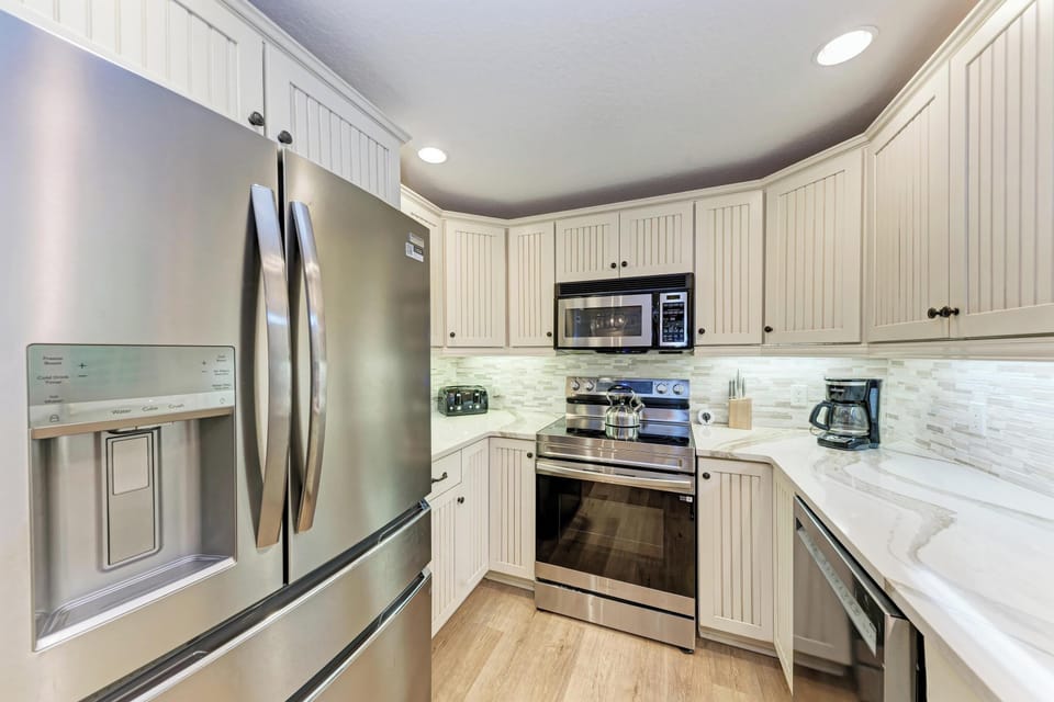 Your fully equipped kitchen features stainless steel appliances and elegant white cabinetry, perfect for preparing meals during your stay.