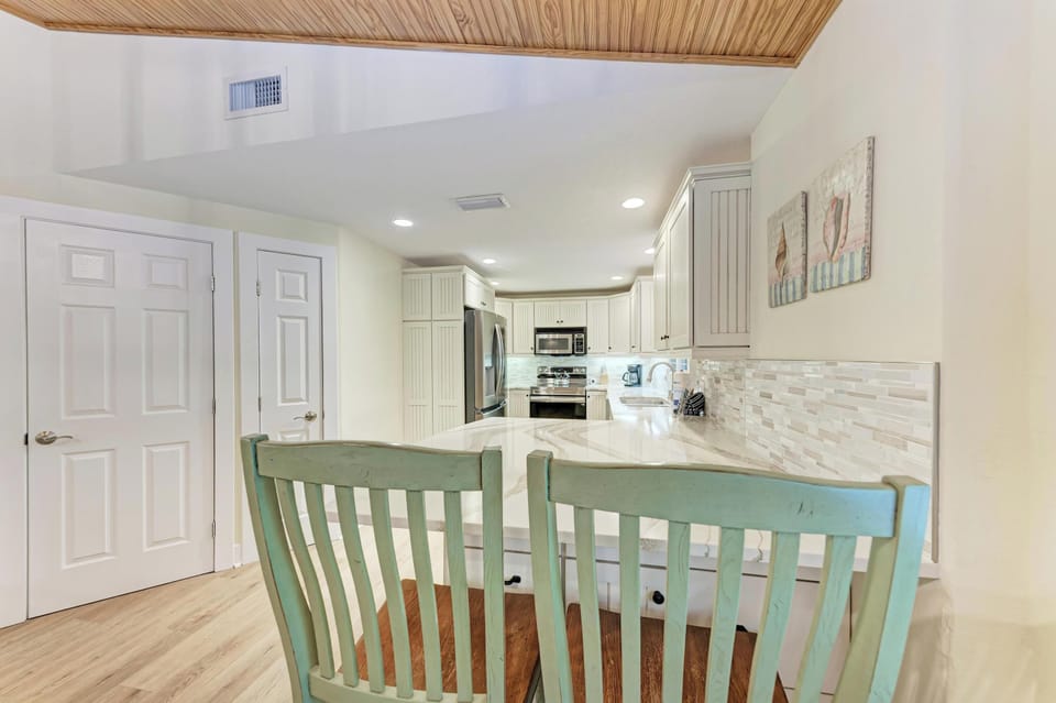 Your bright coastal kitchen features modern appliances and a breakfast bar perfect for morning coffee conversations.