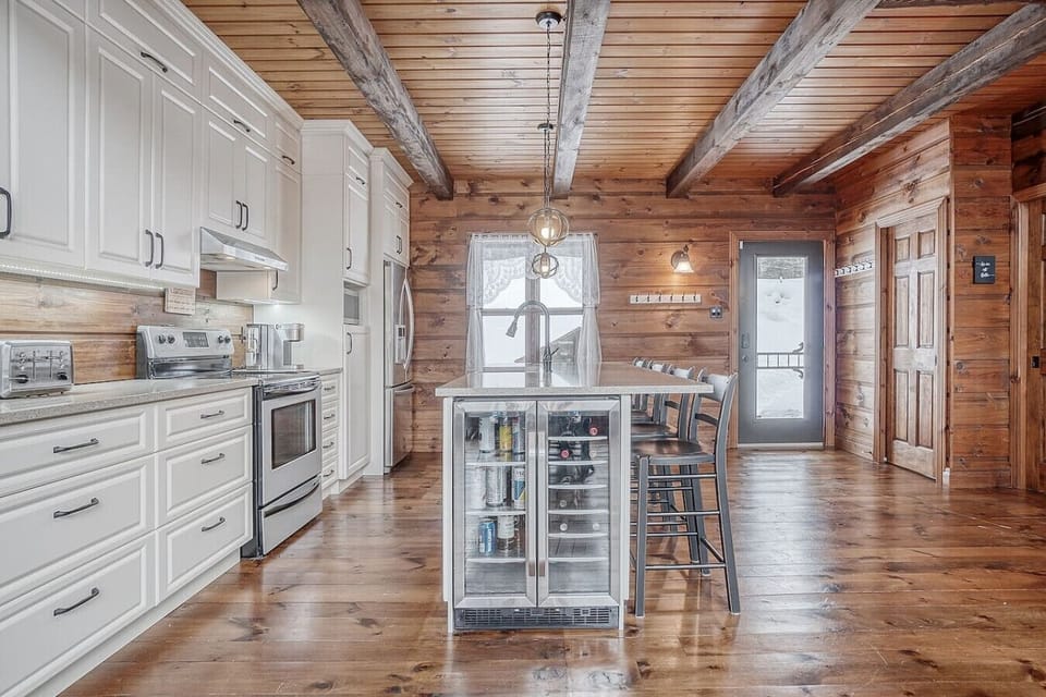 The bright kitchen offers ample counter space, a wine fridge, and direct deck access.