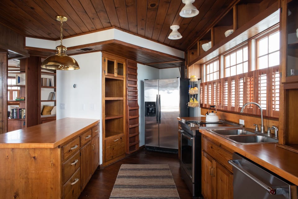 The kitchen has an open layout with fridge, dishwasher and electric range. 