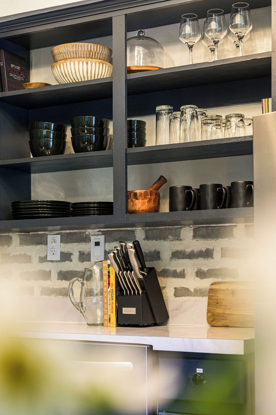 Open shelving adds charm and function - stocked with everyday dishes and thoughtful touches that make the kitchen feel like home.