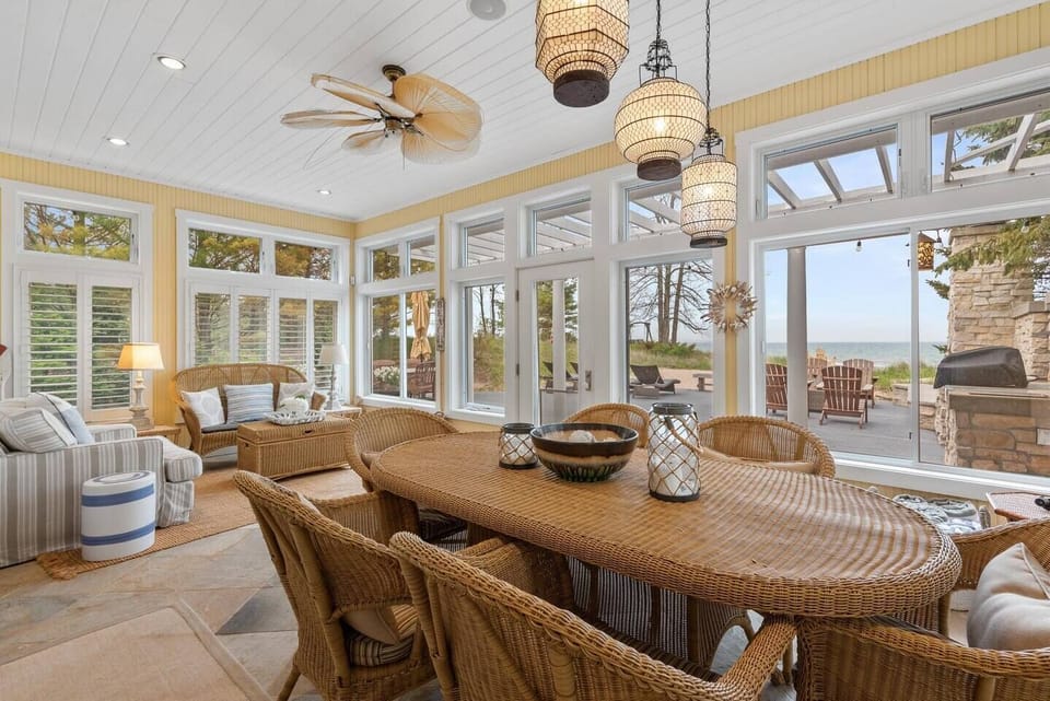 Airy three-season porch w/ high ceilings & expansive windows.