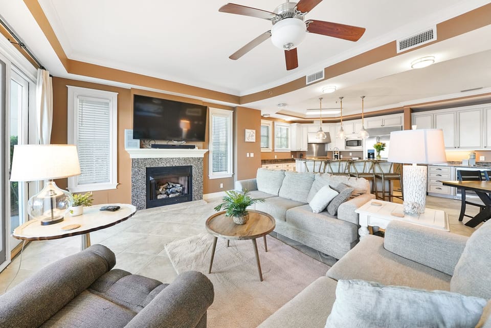 Sink into plush seating by your cozy fireplace, where warm earth tones and modern comfort create your perfect home base.