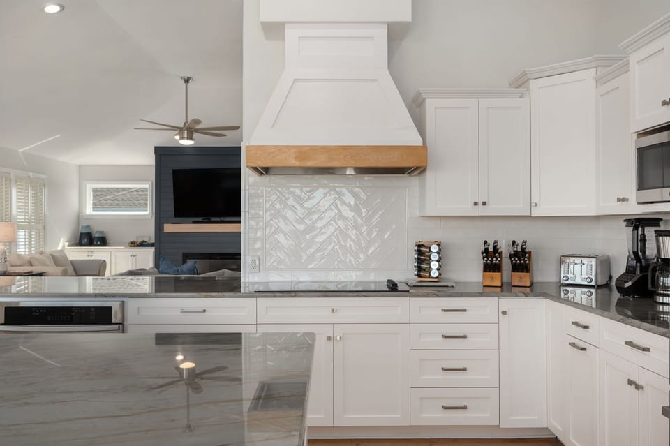 Stunning, updated kitchen with a large island and additional peninsula countertop, two refrigerators, two freezers, two ovens, two dishwashers, electric stove, 10 counter height seats, countertop appliances and more