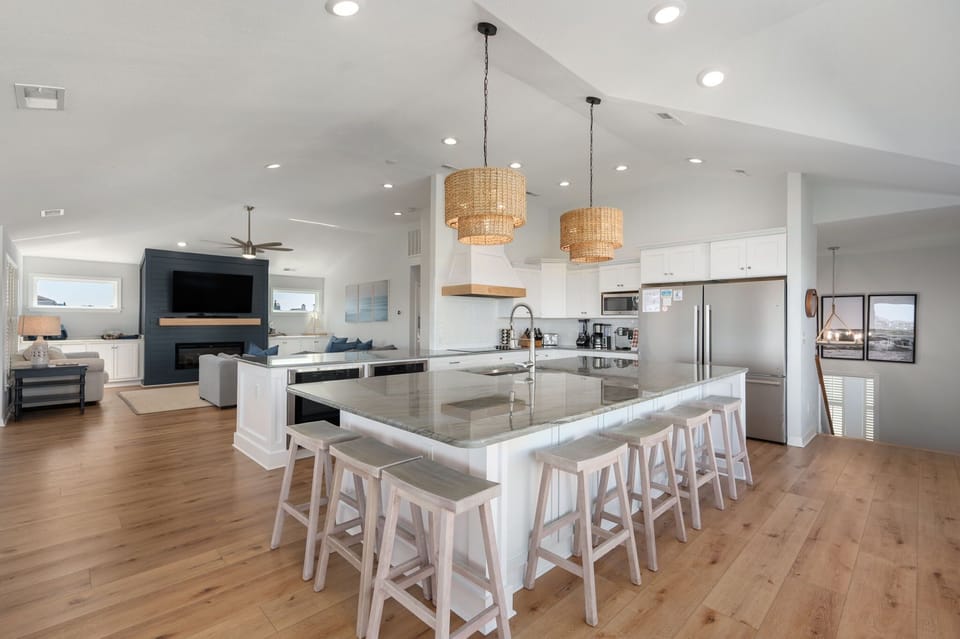Stunning, updated kitchen with a large island and additional peninsula countertop, two refrigerators, two freezers, two ovens, two dishwashers, electric stove, 10 counter height seats, countertop appliances and more