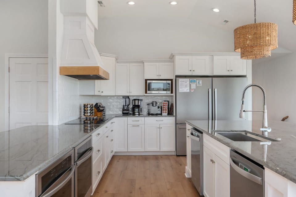 Stunning, updated kitchen with a large island and additional peninsula countertop, two refrigerators, two freezers, two ovens, two dishwashers, electric stove, 10 counter height seats, countertop appliances and more