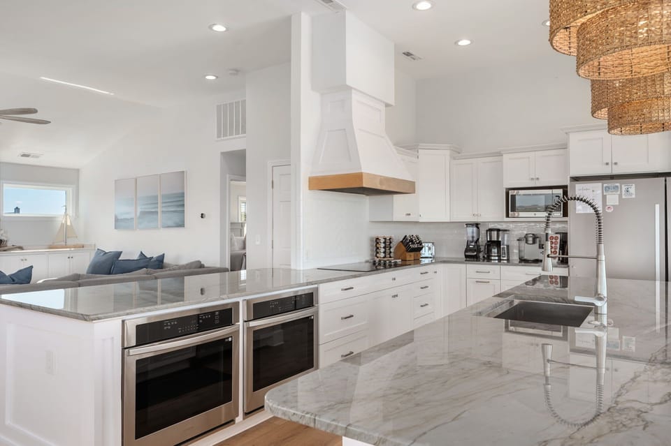 Stunning, updated kitchen with a large island and additional peninsula countertop, two refrigerators, two freezers, two ovens, two dishwashers, electric stove, 10 counter height seats, countertop appliances and more