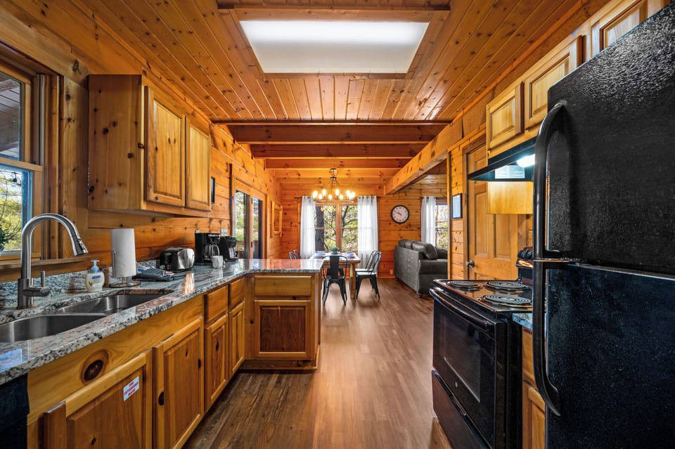 The fully stocked kitchen has tons of plates, silverware, pots, pans, cooking utensils, and other gadgets for cooking.