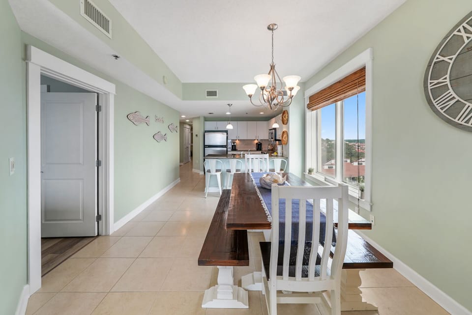 Gather around your spacious dining table where coastal charm meets comfort—sunlight streams through windows as you share meals in this airy, open space.