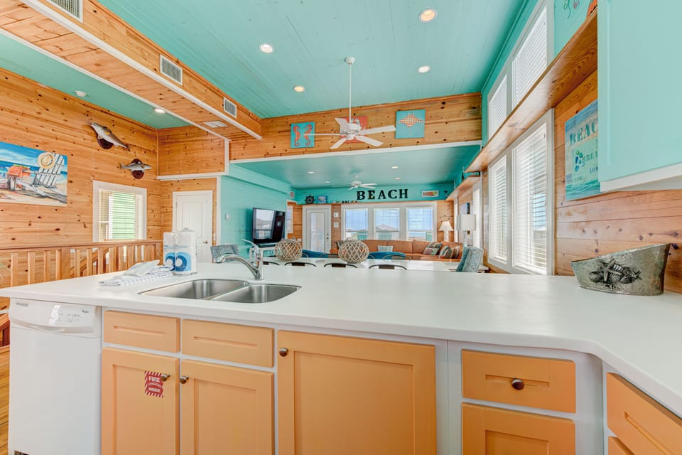 Prepare coastal meals in your bright kitchen, featuring beach-themed touches and an open flow to the living area.