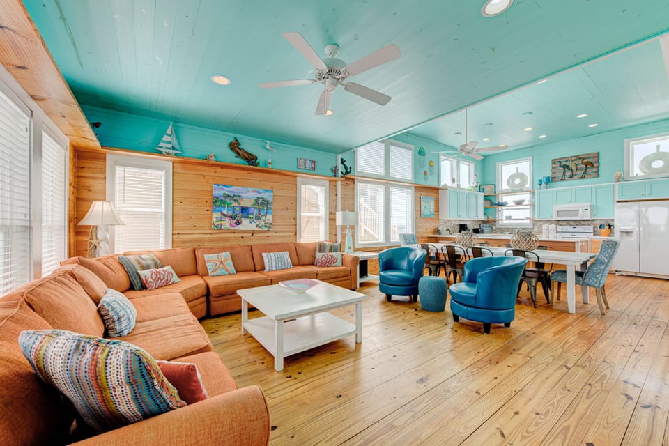 Relax in your coastal retreat with soaring turquoise ceilings, plush seating, and an open kitchen perfect for gathering.