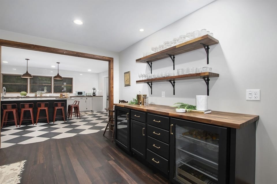 Custom wine bar has two wine/beer coolers and an assortment of glasses