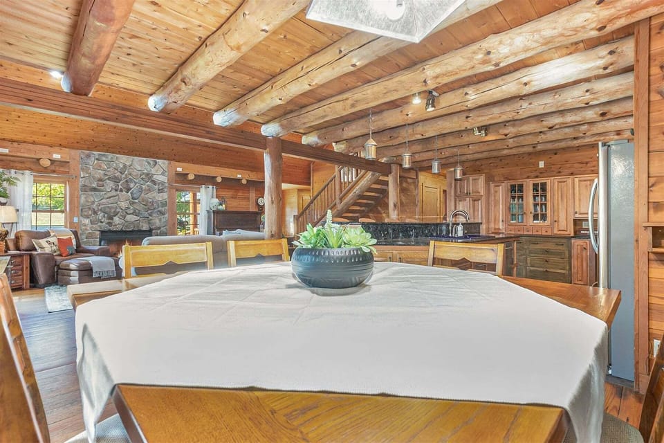Dining table adjacent to the living and kitchen has stools for 8