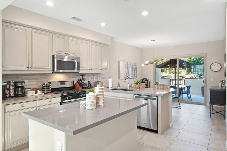 Modern kitchen w/ large island, bar seating & stainless appliances for easy meals together