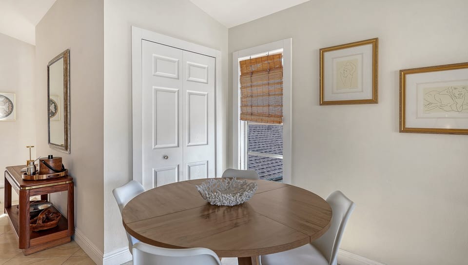 Cozy dining nook with round table and white upholstered chairs for casual meals