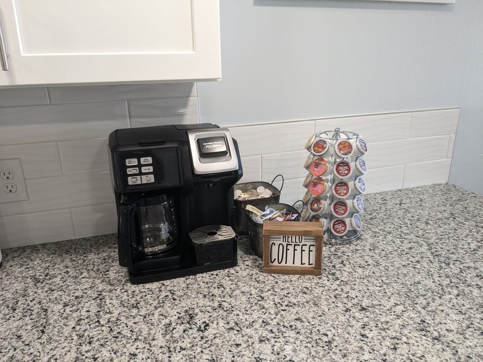 Coffee bar with a drip and Keurig coffee maker and complimentary K-cups.