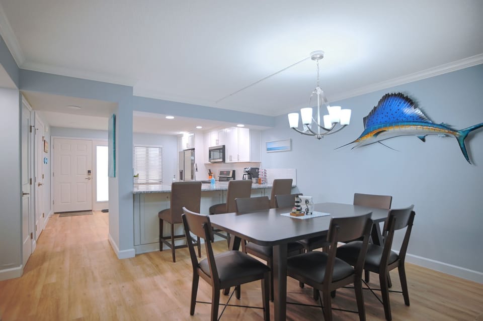 Open dining room with seating for 6 at the table and 3 at the bar