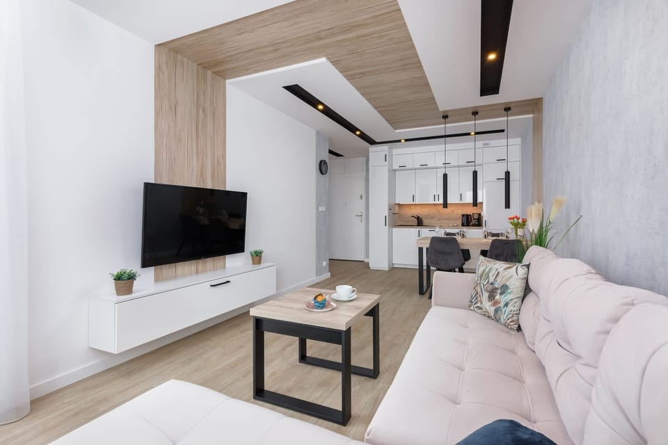 A full view of the living room and kitchen area with stylish wooden accents.
