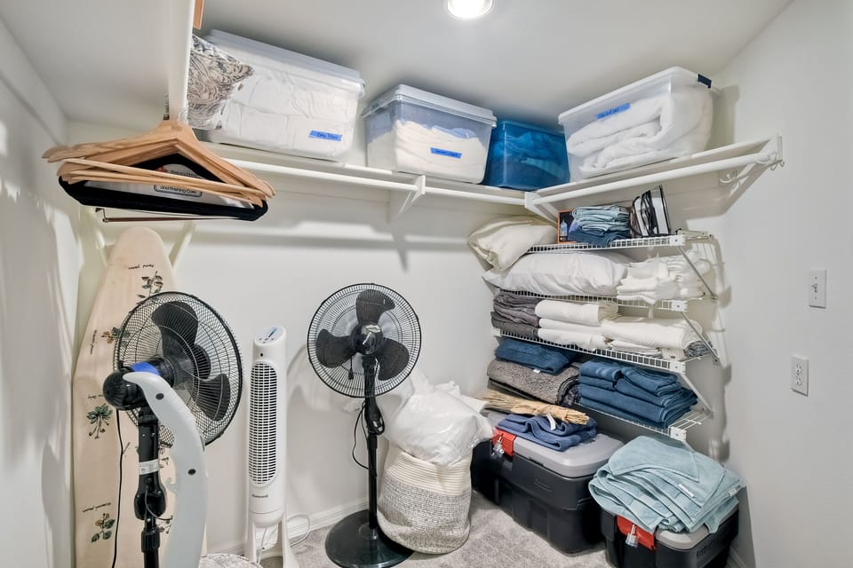 Walk-in closet in master with plenty of extra bedding and portable fans