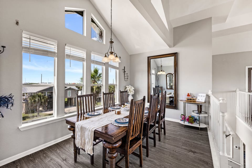 Elegant dining area with large farmhouse-style table, panoramic windows, and open-concept design ideal for family dinners and group gatherings.