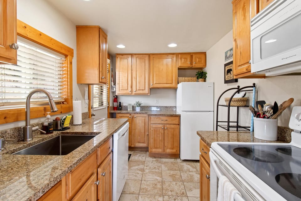 Bright, fully equipped kitchen with granite countertops and natural light