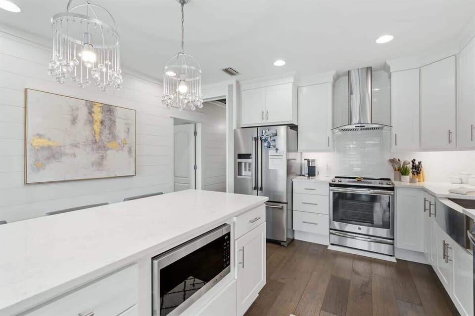 - Bright kitchen with shaker cabinets, quartz countertops, & double chandeliers above the island - Stainless steel range, hood, & fridge offer top functionality with cohesive style - Built in microwave & modern layout make meal prep simple & smooth