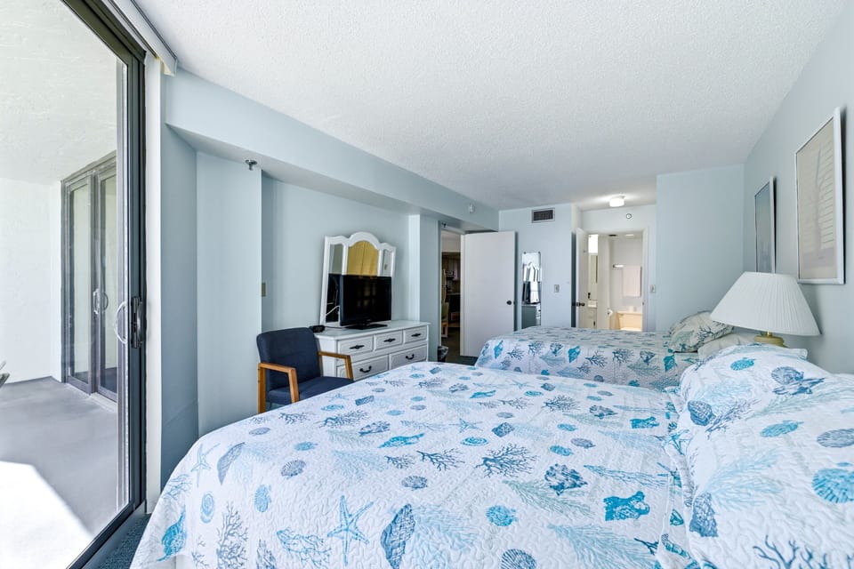 The bedroom has two queen-sized beds.