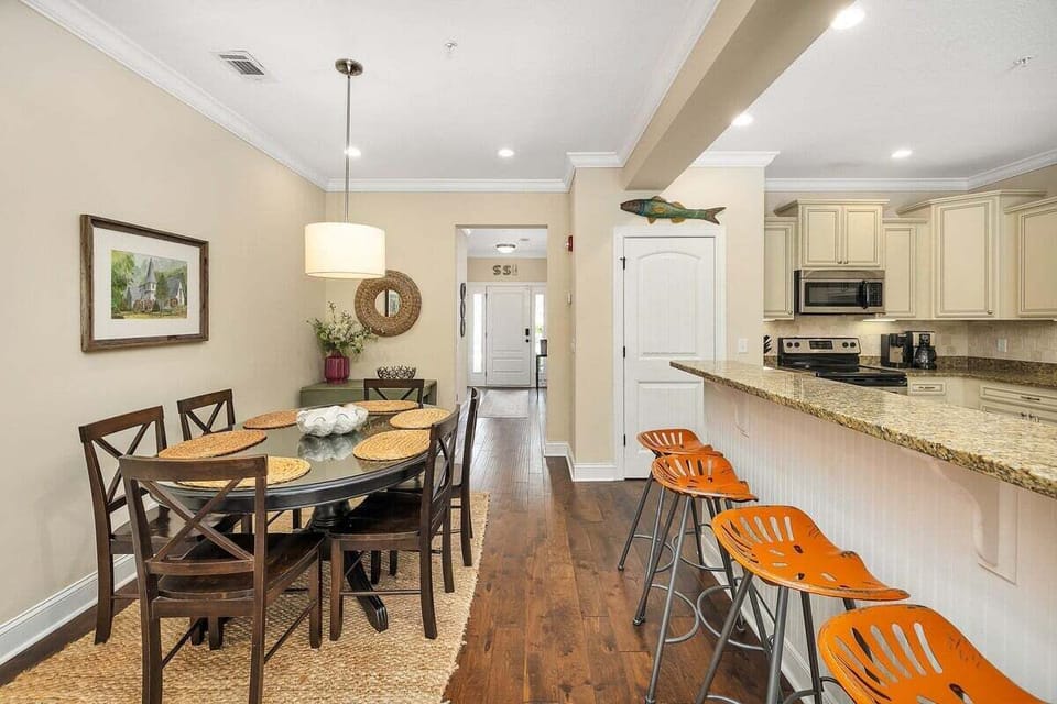 Dining area with table seating six and view into kitchen