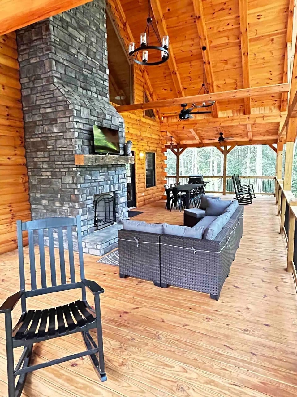 Deck with gas fireplace, grill, dining table, and rocking chairs